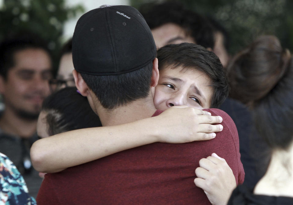 Youths comfort each other at the funeral of elementary school principal Elsa Mendoza, of one of the 22 people killed in a shooting at a Walmart in El Paso, in Ciudad Juarez, Mexico, Thursday, Aug. 8, 2019. Mexican officials have said eight of the people killed in Saturday's attack were Mexican nationals. (AP Photo/Christian Chavez)