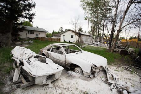 A burnt automobile and boat are seen as thousands of evacuees who fled a massive wildfire begin to return to their homes in Fort McMurray, Alberta, Canada June 1, 2016. REUTERS/Topher Seguin