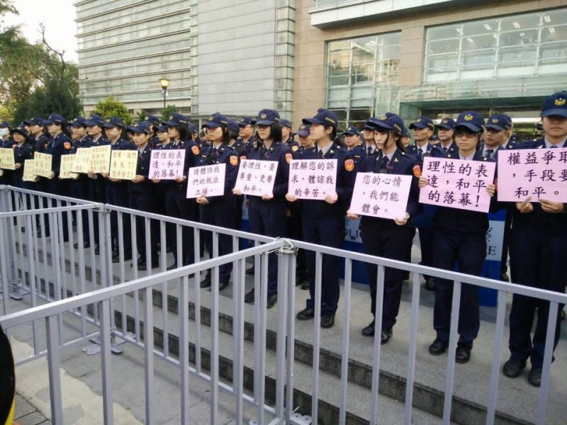2017年1月7日年金改革分區座談會場，女警站在第1排，手持標語呼籲抗議者理性表達，和平落幕。（翻攝自臉書）