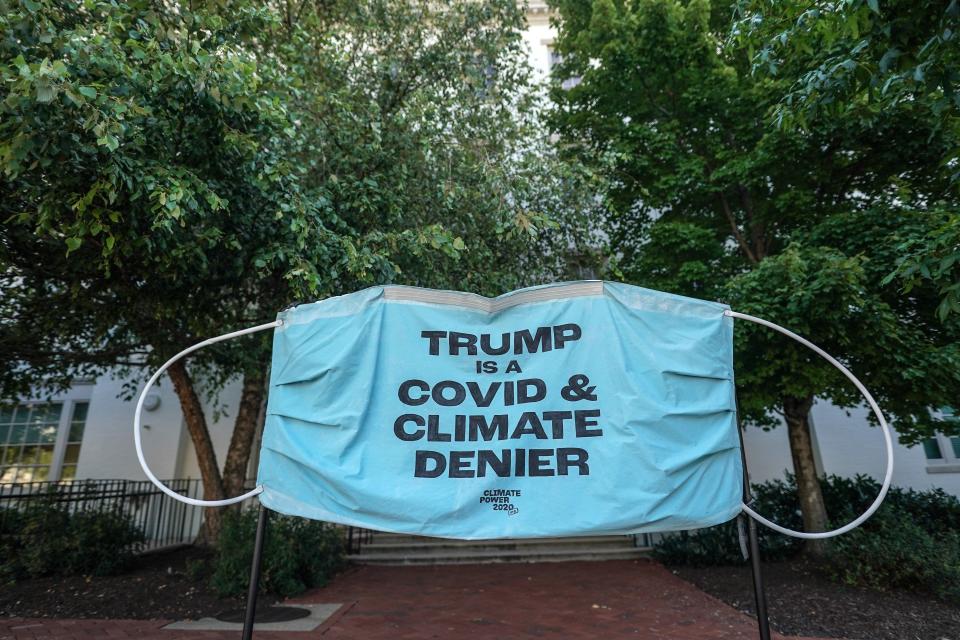 A banner protests President Donald Trump's pandemic and climate change response at the Republican National Convention's headquarters on Aug. 24. (Jemal Countess via Getty Images)