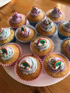 A plate of cupcakes decorated with rainbows.