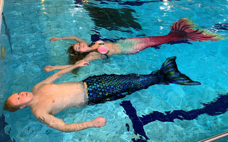 Wellness expert Maija Mottonen and her student Markus Parviainen with their mermaid tails swim in the pool in Espoo, Finland January 11, 2019. Picture taken January 11, 2019. REUTERS/Attila Cser