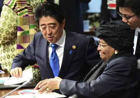 Japanese Prime Minister Shinzo Abe talks with Liberia's President Ellen Johnson Sirleaf prior to the second working session of the G7 summit at the Elmau castle in Kruen near Garmisch-Partenkirchen, Germany, June 8, 2015. REUTERS/John Macdougall/Pool