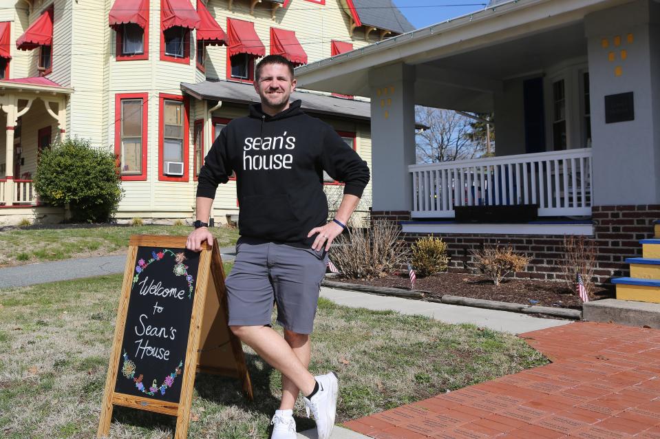 Scott Day, Executive Director of Sean's House, stands next to a sign welcoming visitors to the Newark home.  The site, named after Sean Locke who committed suicide in 2018, acts a safe haven for teenagers and young adults.