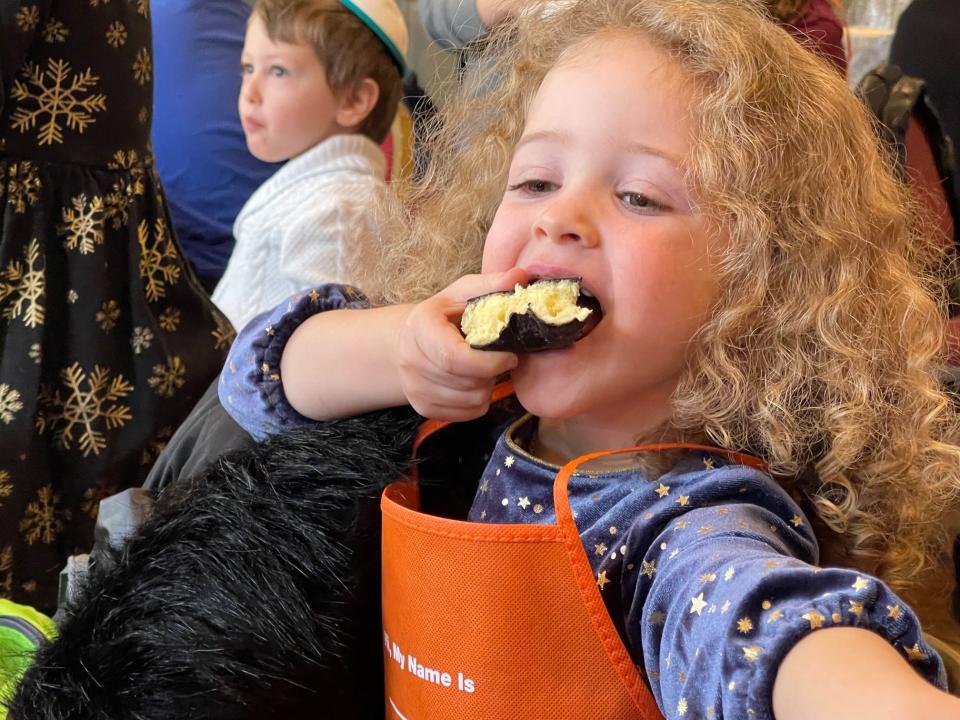 While jelly donuts known as sufganiyah are traditional Hanukkah fare, Rachel Nash, 4, of Exeter, was happy to enjoy a chocolate covered donut at a menorah building workshop at the Seacoast Jewish Center on Sunday, Nov. 21, 2021.