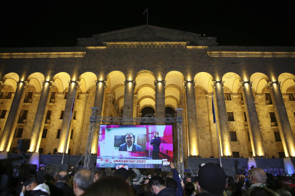 Supporters of Georgian ex-President Mikheil Saakashvili's United National Movement watch his address on a big screen in front of the Parliament's building after the parliamentary elections in Tbilisi, Georgia, Saturday, Oct. 31, 2020. The Georgian Dream party, created by billionaire Bidzina Ivanishvili has claimed victory in the election hotly contested by an alliance formed around the country's ex-President Mikheil Saakashvili, who is in self-imposed exile in Ukraine. (AP Photo/Zurab Tsertsvadze)