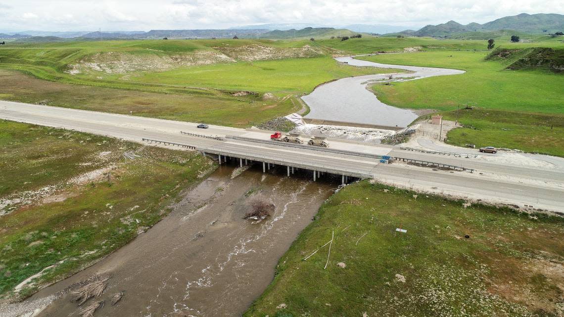 Water swells along the banks of the Dry Creek overflow while moving toward the San Joaquin River near Ball Ranch on North Friant Road on Wednesday, March 8, 2023. Heavy rain from a warm atmospheric river is forecast for the next few days causing alarm for possible flooding.