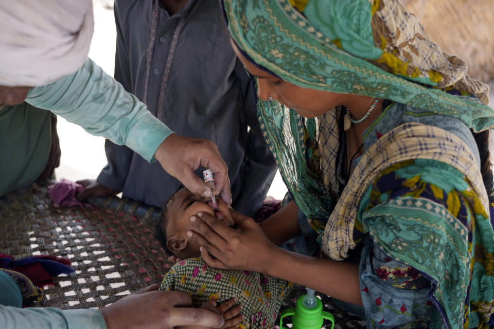 A health worker administers a polio vaccine to a child in a neighborhood of Lahore, Pakistan, Monday, June 3, 2024. (AP Photo/K.M. Chaudary)