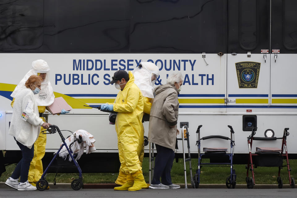 Medical officials aid a residents from St. Joseph's nursing home to board a bus, after a number of residents tested positive for coronavirus disease (COVID-19) in Woodbridge, New Jersey