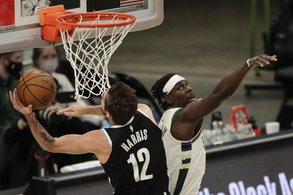 Brooklyn Nets' Joe Harris (12) shoots past Milwaukee Bucks' Jrue Holiday during the first half of an NBA basketball game Tuesday, May 4, 2021, in Milwaukee. (AP Photo/Aaron Gash)