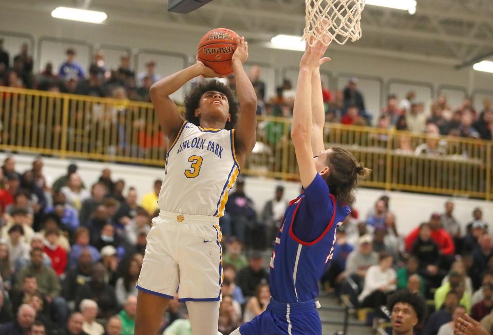 Lincoln Park's Brandin Cummings (3) goes for a layup while being guarded by Laurel Highland's Patrick Cavanagh (15) during the first half of the PIAA 4A Quarterfinals game Friday night at Hampton High School in Allison Park, PA.