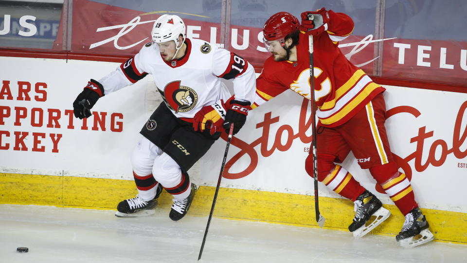 Ottawa Senators' Drake Batherson, left, and Calgary Flames' Rasmus Andersson chase the puck during second-period NHL hockey game action in Calgary, Alberta, Sunday, March 7, 2021. (Jeff McIntosh/The Canadian Press via AP)