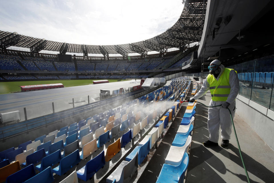 A cleaner wearing a protective suit sanitises seats at the San Paolo stadium ahead of the second leg of the Coppa Italia semi-final between Napoli and Inter Milan, which has since been postponed as part of measures to contain the coronavirus outbreak, in Naples, Italy, March 4, 2020. REUTERS/Ciro De Luca