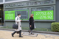 People walk by an electronic stock board of a securities firm in Tokyo, Monday, Dec. 6, 2021. Shares were mixed in Asia on Monday after troubled Chinese property developer Evergrande warned late Friday it may run out of money. (AP Photo/Koji Sasahara)