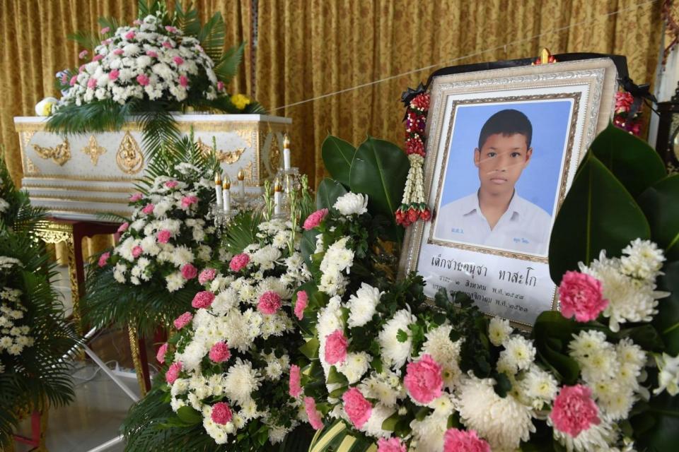 A portrait of 13-year-old Anucha Tasako next to his coffin during his funeral at a Buddhist temple in the Samut Prakan province of Thailand on Wednesday (Romeo Gacad/AFP/Getty Images)