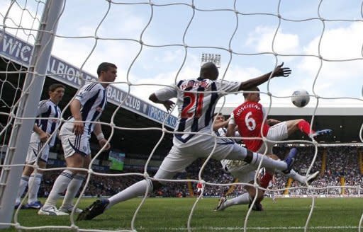 Arsenal's Laurent Koscielny (R) scores during their English Premier League match against West Bromwich Albion at The Hawthorns in West Bromwich, on May 13. Arsenal sealed third place in the league and a guaranteed spot in next season's Champions League with their 3-2 win