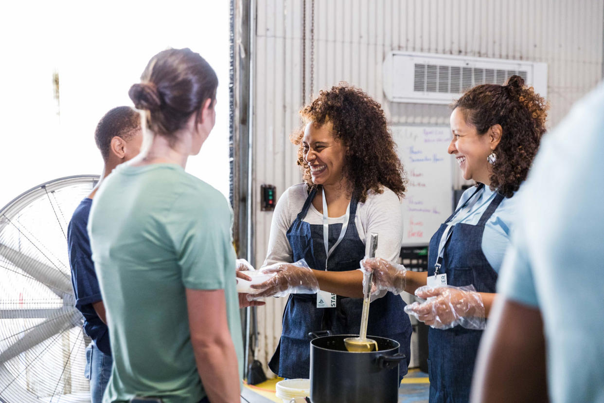 Mother and daughter volunteer to serve hungry food bank clients (SDI Productions / Getty Images)