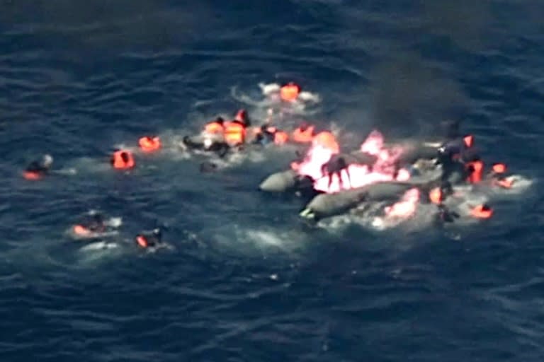 Image grab from handout video footage by the Portuguese air force shows migrants in the water waiting for rescue after their boat caught fire