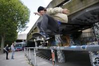 A skateboarder performs a jump over a railing at Southbank in central London, Britain June 3, 2015. REUTERS/Stefan Wermuth