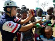 The Costa Rican Red Cross distributes food to migrants at the encampment in Penas Blancas