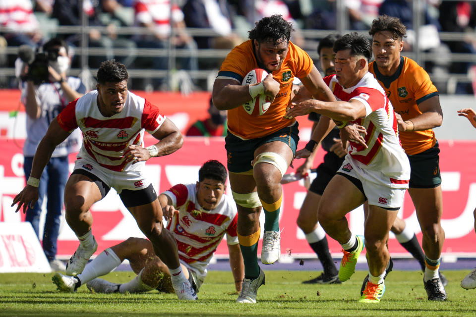 Australia's Rob Leota, centre, makes a run at the defense during the rugby international between the Wallabies and Japan in Oita, Japan, Saturday, Oct. 23, 2021. (AP Photo/Hiro Komae)