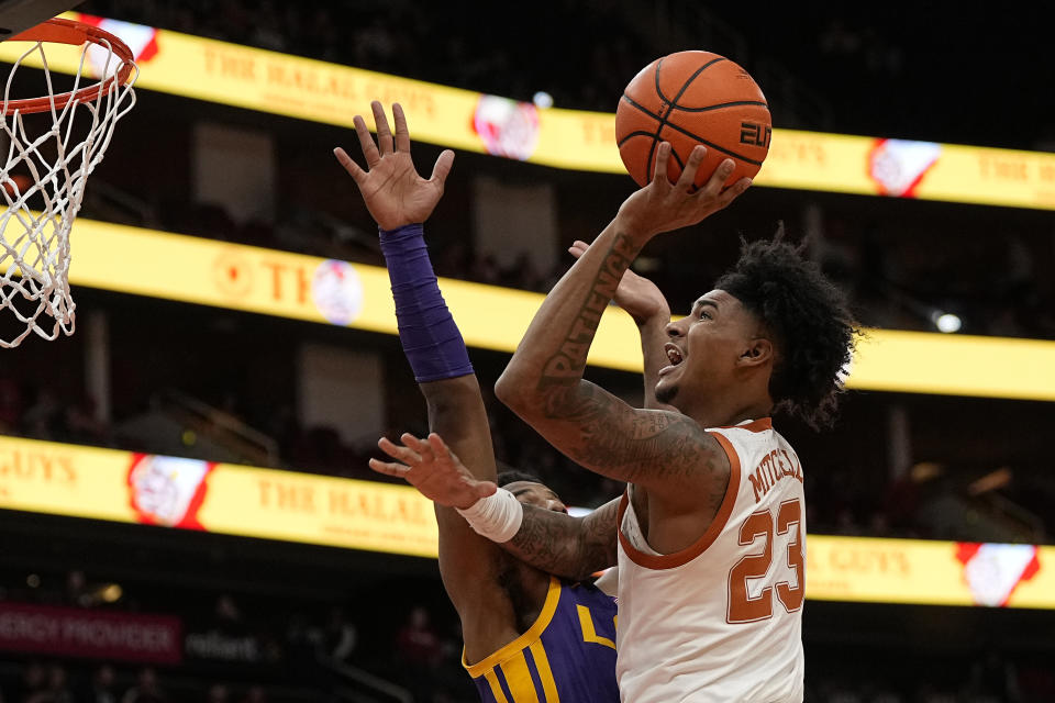 Texas forward Dillon Mitchell (23) scores over LSU guard Jordan Wright during the first half of an NCAA college basketball game, Saturday, Dec. 16, 2023, in Houston. (AP Photo/Kevin M. Cox)