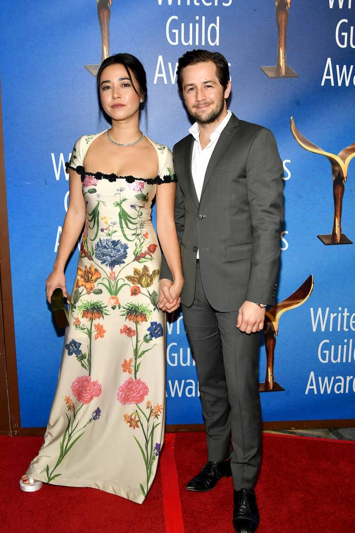 the couple holding hands on the red carpet