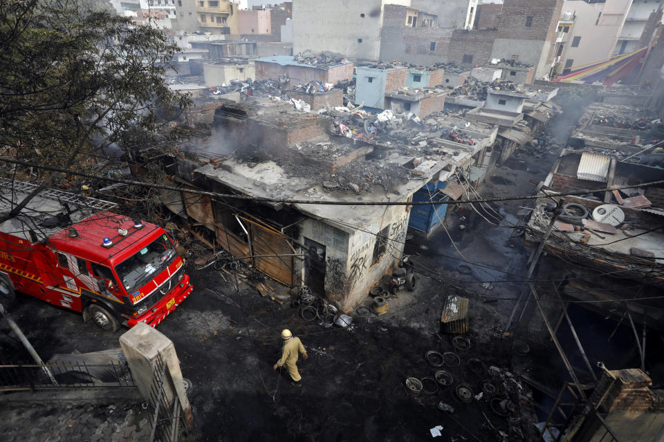 A firefighter walks past damaged shops at a tyre market after they were set on fire by a mob in a riot affected area after clashes erupted between people demonstrating for and against a new citizenship law in New Delhi, India, February 26, 2020. REUTERS/Adnan Abidi