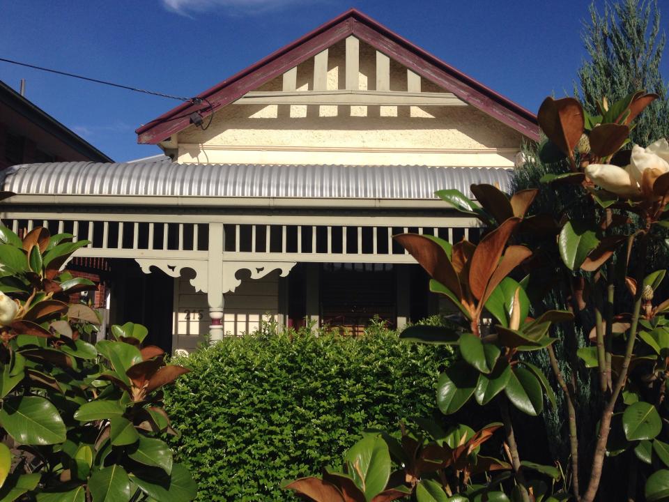 BEFORE: The original structure had a classic Edwardian cottage with a small layout, including one dark bedroom at the front, a gabled roof, a weatherboard exterior, and a surrounding veranda. In the update, Wesley moved the veranda farther out, managing to bring more natural light into the front bedroom.