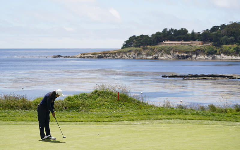 Allisen Corpuz putts on the fourth hole during the final round of the U.S. Women's Open golf tournament. In the distance is seen the ocean and a stretch of land.