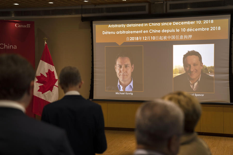 A video screen displays images of Canadians Michael Kovrig, left, and Michael Spavor at an event held in connection with the announcement of the sentence for Spavor at the Canadian Embassy in Beijing, Wednesday, Aug. 11, 2021. A Chinese court has sentenced Spavor to 11 years on spying charges in case linked to Huawei. (AP Photo/Mark Schiefelbein)