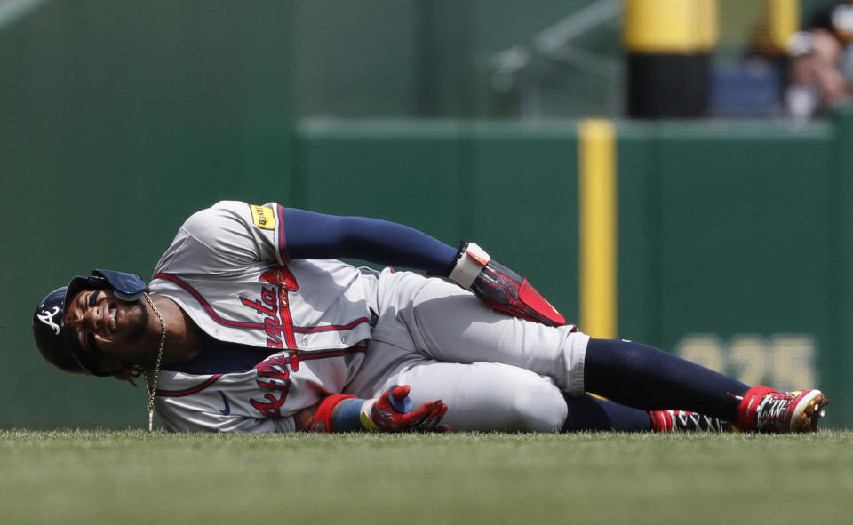 Ronald Acuña Jr. holds his leg in pain after injuring his left knee on Sunday. (Charles LeClair/Reuters)