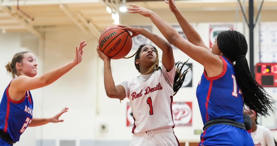 Pike Red Devils guard Saniya Smith (1) attempts a lay-up against Roncalli Royals center Jasmine Horsman (14) on Tuesday, Nov. 14, 2023, during the game at Pike High School in Indianapolis.