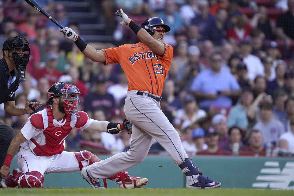 Houston Astros' Michael Brantley follows through on a two-run single in front of Boston Red Sox catcher Connor Wong during the third inning of a baseball game Wednesday, Aug. 30, 2023, in Boston. (AP Photo/Steven Senne)