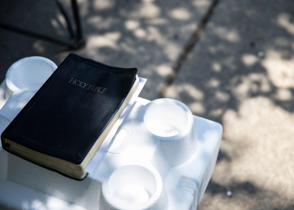 A Bible is seen on a table on a sidewalk.