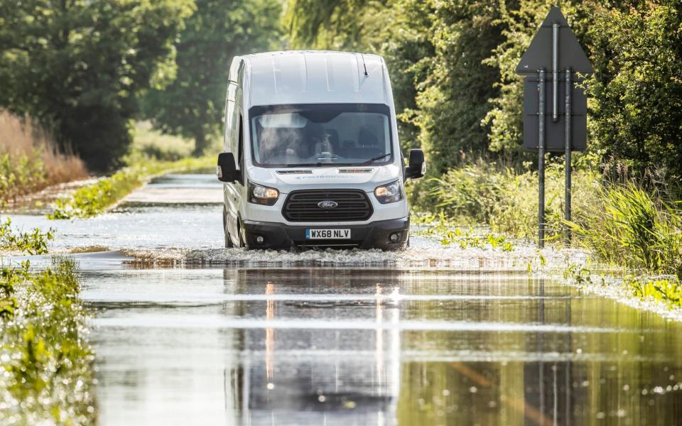 A van drives through floodwater in Wainfleet All Saints, in Lincolnshire, where streets and properties flooded - PA