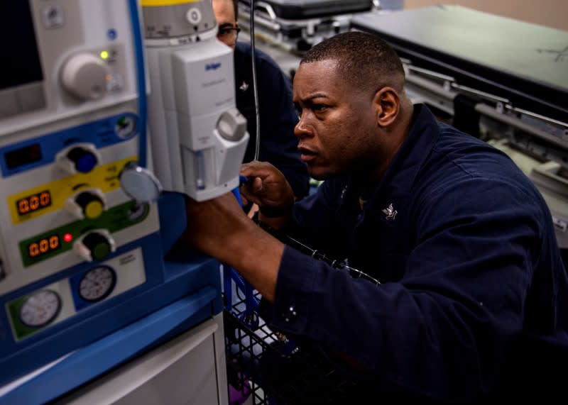 Hospital Corpsman reconnects hoses to an anesthesia machine aboard the Military Sealift Command hospital ship USNS Mercy