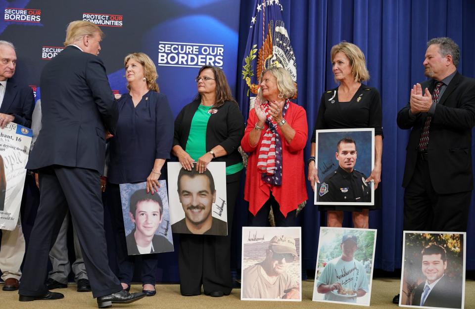 President Trump on Friday greets people holding posters of loved ones killed by undocumented immigrants. (Photo: Mandel NGAN/AFP/Getty Images)