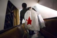 Shoppers ride the escalator at Macy's Herald Square in New York in this November 28, 2013 file photo. U.S. consumers shopped less on the final weekend before Christmas despite deeper discounts, the latest sign of how difficult a season this is turning out to be for retailers. Picture taken November 28, 2013. REUTERS/Eric Thayer