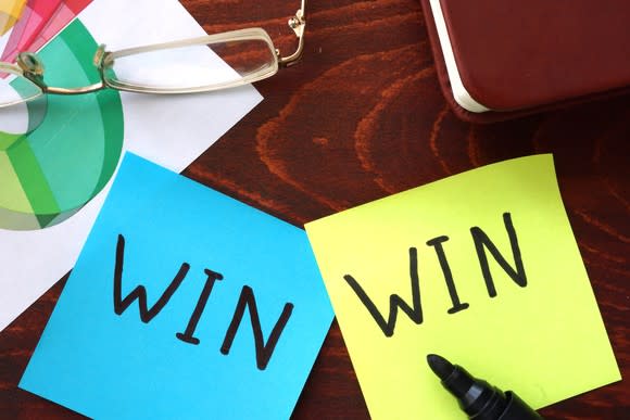 Two Post-it notes side by side, each with the word "WIN" printed on them with a black marker.