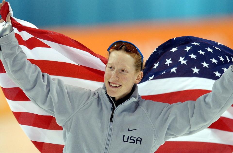 Speedskater Chris Witty holds an American flag around her as she skates her victory lap after setting a world record in the women’s 1,000 meter Feb. 17, 2002. | Scott G Winterton, Deseret News