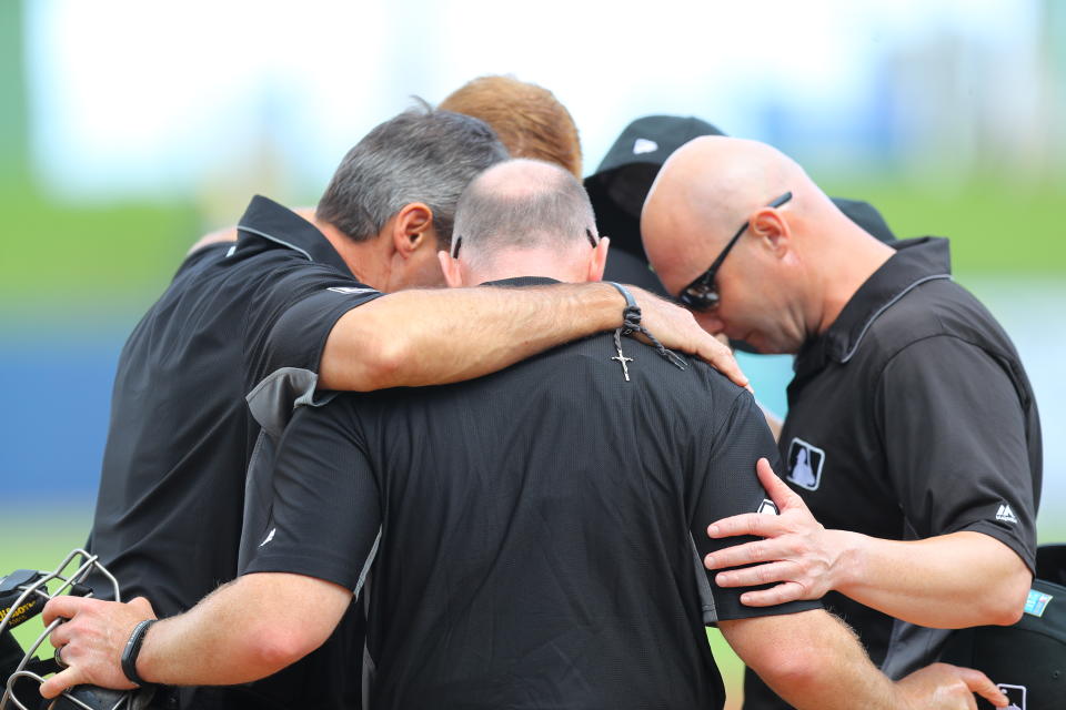 Umpires pray at home plate