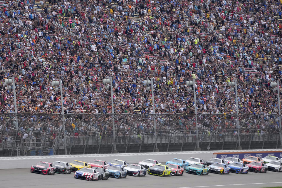 Christopher Bell (20) leads the field to the start during a NASCAR Cup Series auto race at Michigan International Speedway in Brooklyn, Mich., Sunday, Aug. 6, 2023. (AP Photo/Paul Sancya)