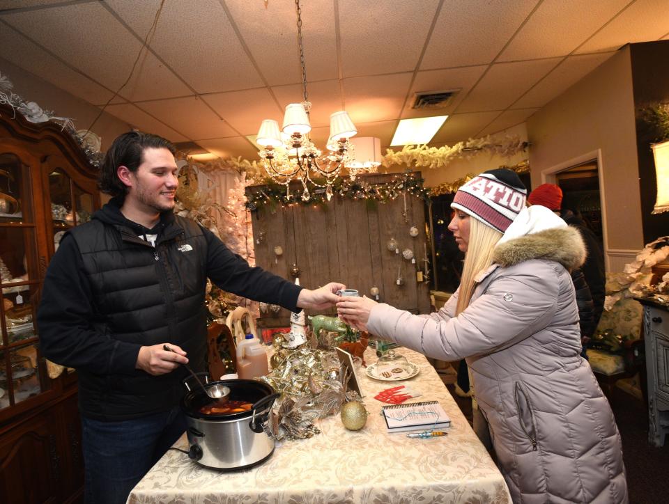 Brandon Hudson, left, pours a taste of spiced wine to Amanda Ollila of Toledo during Blissfield's Wassail Fest on Dec. 7, 2018, in Blissfield. This year's Wassail Fest is Friday, Dec. 8, and will be held nearly simultaneously with the Hot-Cha-Cha 5K Mug Run that serves as fundraiser for the Miss River Raisin Scholarship Program.