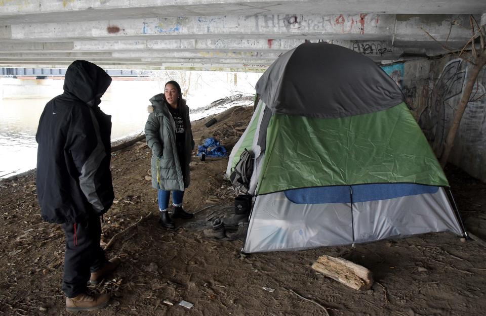 Tara Bijarro, a certified peer recovery specialist and director of recovery services for Oaks of Righteousness Church, talks to a homeless couple underneath the North Dixie Bridge along the River Raisin in Monroe in January 2023.