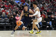 Notre Dame forward Nate Laszewski (14) attempts to drive past the defense of Louisville forward Samuell Williamson (10) during the first half of an NCAA college basketball game in Louisville, Ky., Saturday, Jan. 22, 2022. (AP Photo/Timothy D. Easley)