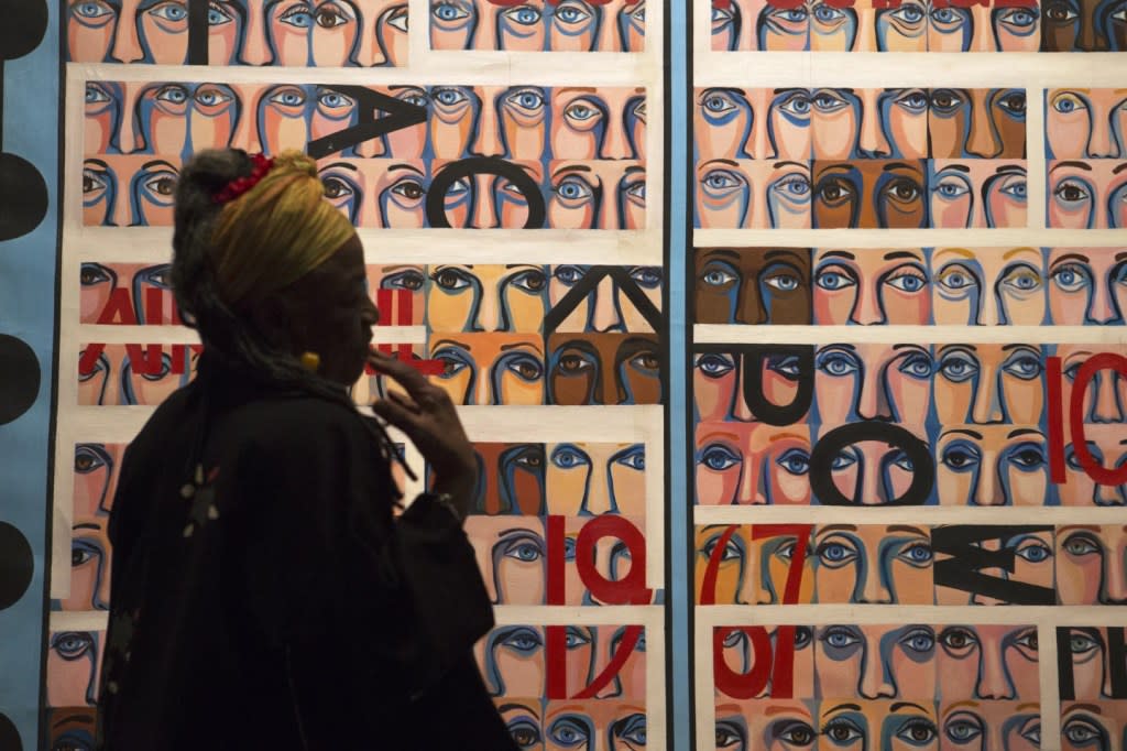 Artist Faith Ringgold talks about her artwork in front of her painting, “U.S. Postage Stamp Commemorating the Advent of Black Power, 1967″ during a preview of her exhibition, American People, Black Light: Faith Ringgold’s Paintings of the 1960s at the National Museum of Women in the Arts in Washington, June 19, 2013. (AP Photo/Jacquelyn Martin, File)