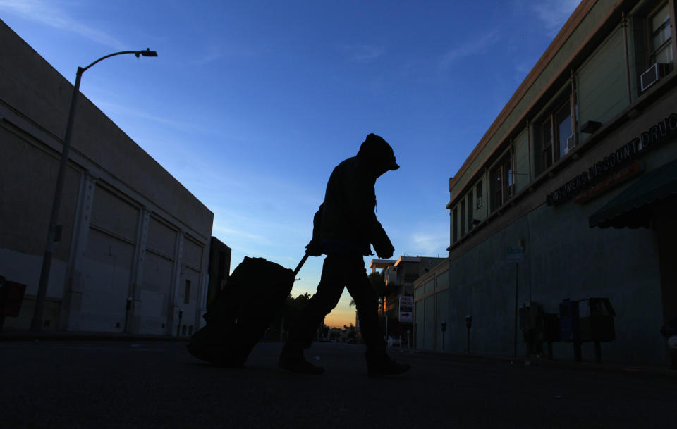 A homeless&nbsp;person makes his way down Los Angeles' Hollywood Boulevard one morning in February 2012.