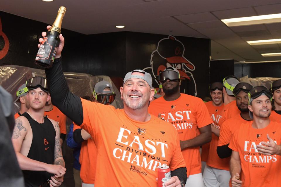 Orioles manager Brandon Hyde (18) celebrates with his players in the locker room at Camden Yards after Baltimore defeated the Boston Red Sox to win the American League East division title.
