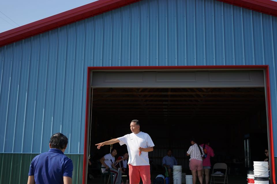 Rup Rai directs customers as the parking area fills up at Rai Farm in Glenford, Ohio.